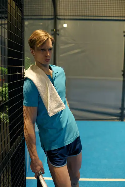 A young athlete leans against the padel court's fence, ready for action. — Stock Photo