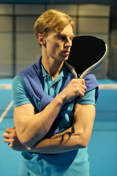 A young man stands poised with a racket, ready for an intense game of padel in sporty attire. — Stock Photo