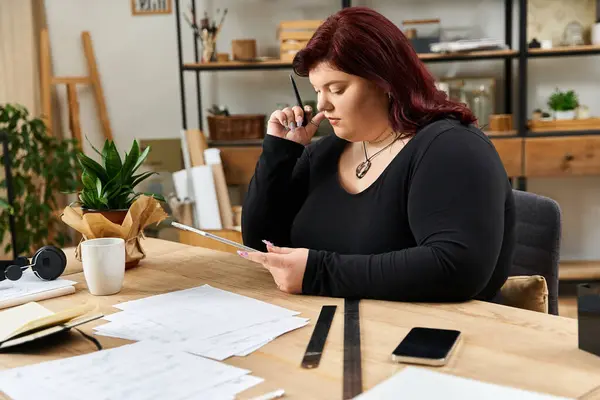 Pretty woman focuses intently on her creative project surrounded by art supplies and inspiration. — Stock Photo
