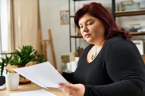 Pretty woman engages thoughtfully with artworks in a bright and inspiring art studio. — Stock Photo