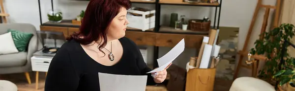 Creative woman examines her artwork thoughtfully in a stylish art studio surrounded by inspiration — Stock Photo