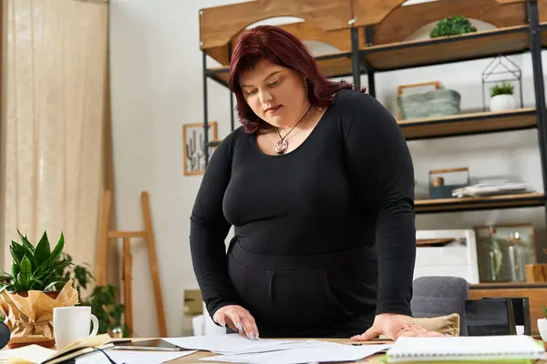 In a bright art studio, a stylish woman explores her creative ideas, immersed in artistic plans. — Stock Photo