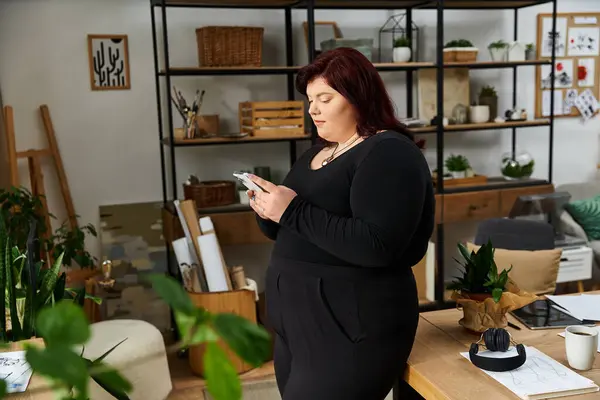 Elegant woman in a chic art studio focusing on her creative project with inspiration all around. — Stock Photo