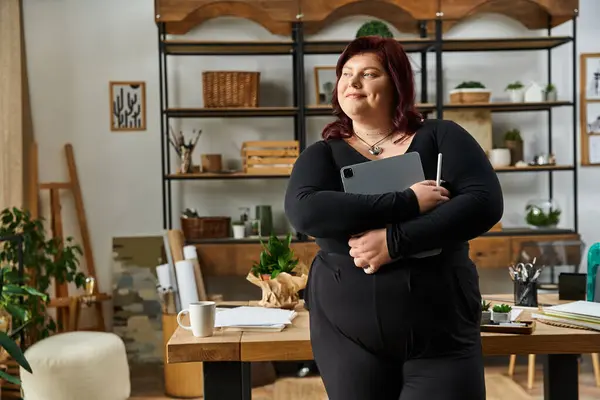 A pretty woman stands confidently in her art studio, surrounded by plants and creative supplies. — Stock Photo