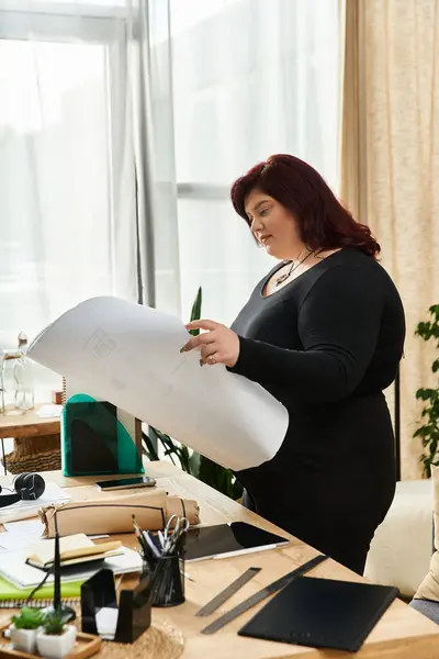 Creative woman explores plans with focus and elegance in a vibrant art studio setting. — Stock Photo
