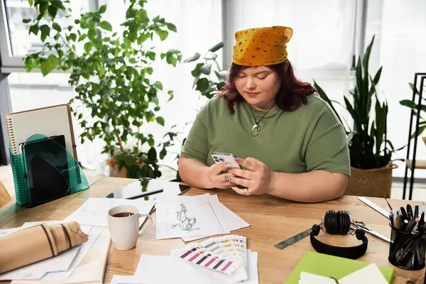 Elegant woman engages with her phone while surrounded by art supplies and inspiring decor. — Stock Photo