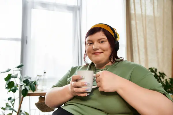 Pretty woman relaxes in art studio, holding a mug and embracing her artistic inspiration. — Stock Photo