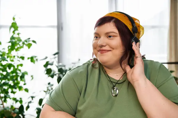 Eine hübsche Frau genießt ihre künstlerische Umgebung, während sie Musik hört, umgeben von viel Grün. — Stockfoto