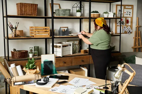 A pretty woman organizes her artistic materials in a stylish and inviting art studio. — Stock Photo