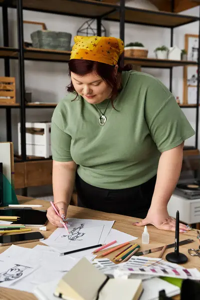 Chic woman immersed in her creative process, sketching in a lively art studio filled with materials. — Stock Photo