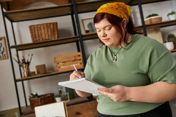 Elegant woman sketches her ideas in a vibrant art studio filled with creativity and inspiration. — Stock Photo