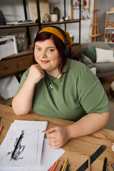 Charming artist engaged in drawing while surrounded by art supplies and a cozy atmosphere — Stock Photo