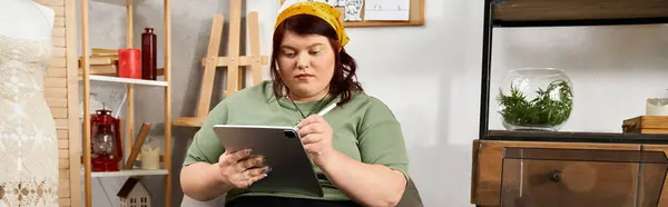En un estudio de arte, una mujer chic dibuja apasionadamente en su tableta, rodeada de inspiración. - foto de stock