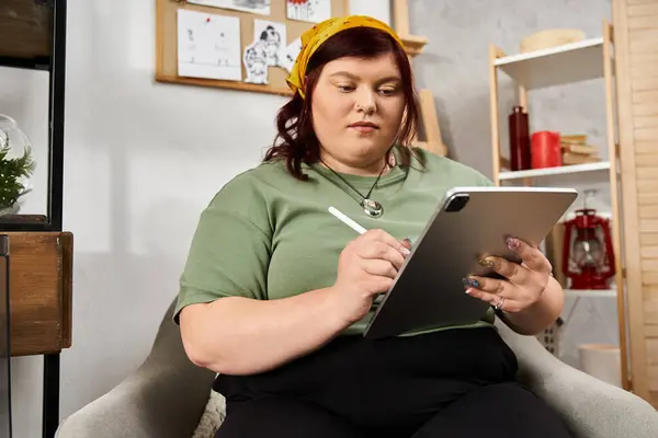 En un animado estudio de arte, una mujer con estilo se involucra con su tableta, inmersa en la expresión creativa. - foto de stock