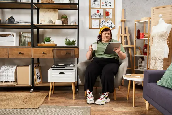 A stylish woman relaxes in a modern art studio, enjoying her creative work and a warm drink. — Stock Photo