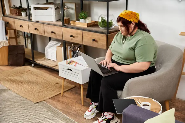 A stylish woman sits in a cozy art studio, focused on her laptop while surrounded by creative tools. — Stock Photo