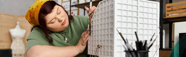 Elegant woman focuses on her creative task while crafting a unique art piece in the studio. — Stock Photo