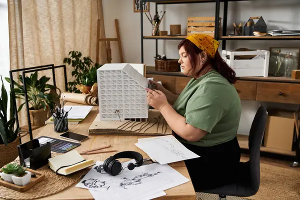 An elegant woman works diligently in her art studio, crafting and surrounded by creative materials. — Stock Photo