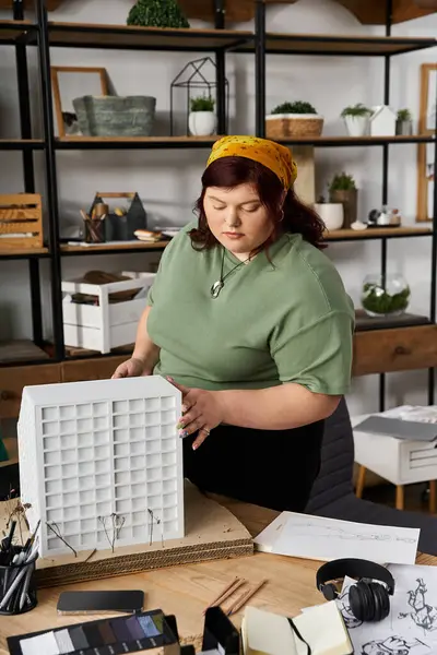Una mujer elegante en su estudio de arte, organizando cuidadosamente los materiales en una mesa de madera. - foto de stock