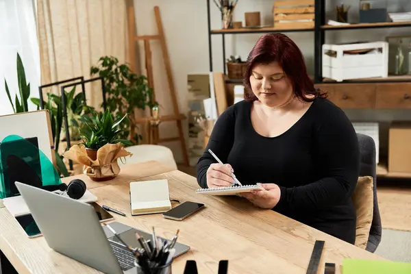 Una mujer bonita inmersa en su proceso artístico en un estudio de arte chic, capturando sus ideas. - foto de stock