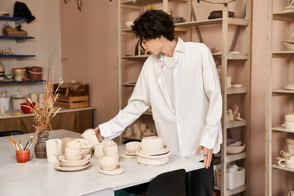 Handsome man shows creativity with handmade ceramics in a bright pottery studio. — Stock Photo