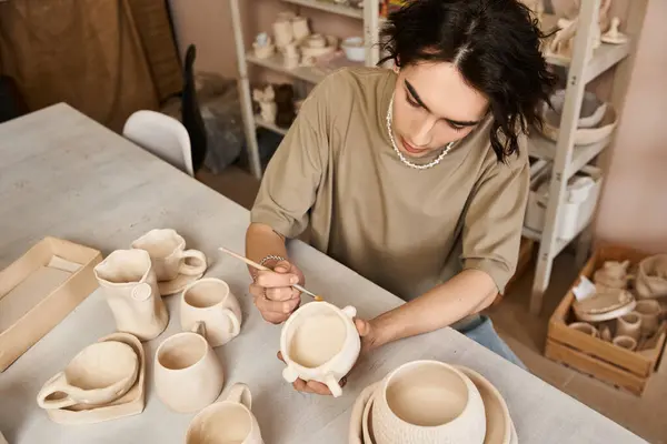 A stylish man passionately sculpts clay pottery in his creative workspace, showcasing artistry. — Stock Photo
