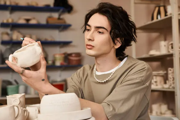 A talented man carefully shapes a pottery piece in a vibrant and creative studio atmosphere. — Stock Photo