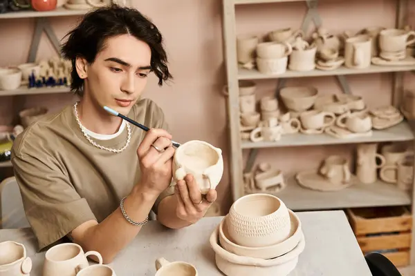 Stylish man carefully details pottery in a bright studio bursting with artistic inspiration. — Stock Photo