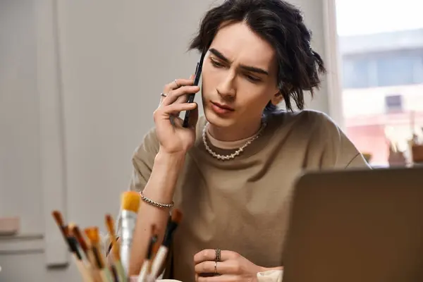 Handsome man talks on his phone while surrounded by pottery tools and creative inspiration. — Stock Photo