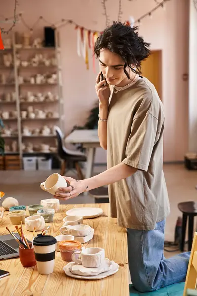 A fashionable man engages in crafting ceramics while surrounded by colorful pottery pieces. — Stock Photo