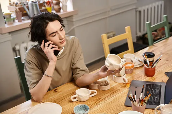 A fashionable man engaged in pottery, crafting unique ceramic pieces while on a phone call. — Stock Photo