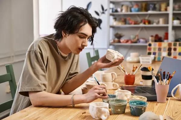 A handsome man skillfully crafts pottery in a vibrant, inspiring studio. — Stock Photo
