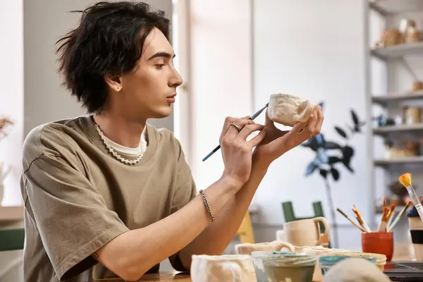 A creative person skillfully molds pottery in a lively studio filled with art tools. — Stock Photo