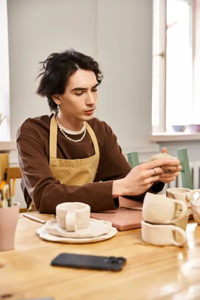 A skilled man focused on crafting unique pottery pieces in a bright and inspiring studio space — Stock Photo