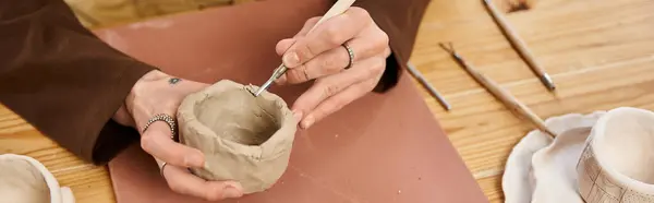 Un hombre con estilo forma expertamente la arcilla en una hermosa pieza de cerámica en un estudio creativo. - foto de stock
