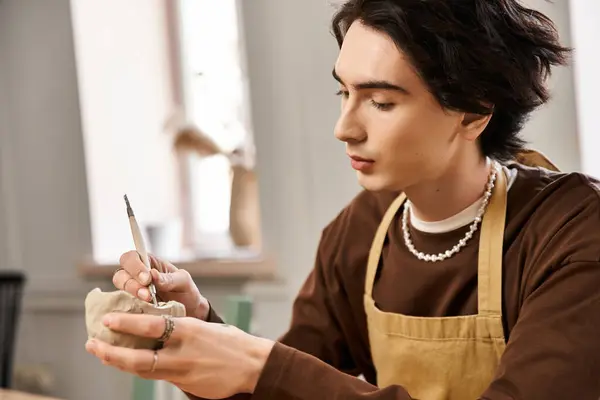 A skilled man meticulously sculpts clay in a vibrant pottery studio, showcasing his artistic talent. — Stock Photo