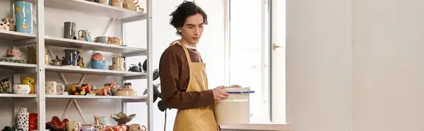 Un hombre creativo se encuentra en un estudio de cerámica, haciendo cerámica con enfoque y estilo. - foto de stock