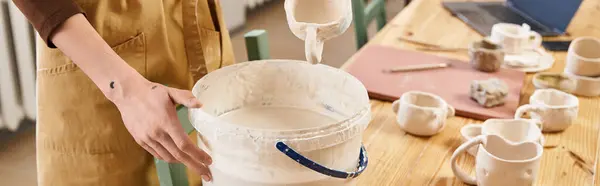 Comprometido en la fabricación de cerámica, un hombre explora su creatividad en un estudio de cerámica bien iluminado. - foto de stock
