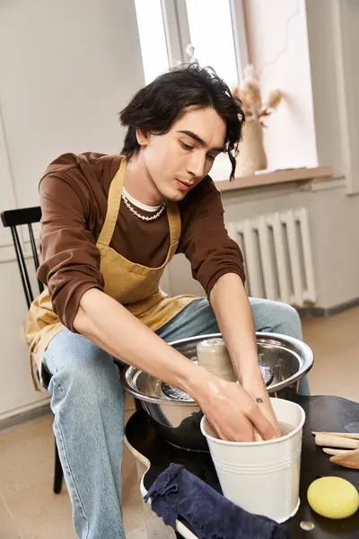 A talented man explores his creativity while crafting pottery in a bright studio. — Stock Photo