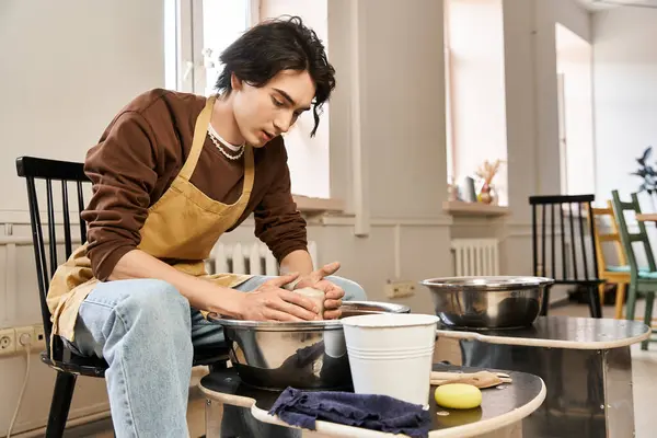 Focused artist shapes clay in a bright pottery studio filled with creative energy and inspiration. — Stock Photo