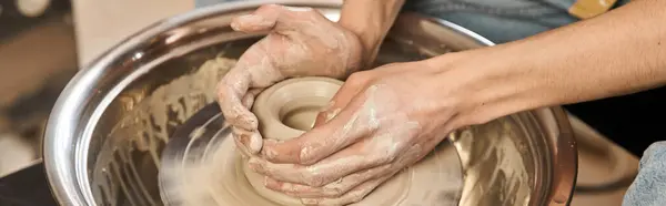 A creative man shapes clay on a pottery wheel in an inspiring art studio. — Stock Photo