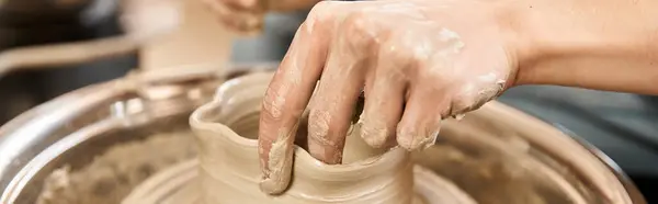 A handsome man skillfully shapes clay on a pottery wheel, surrounded by artistic inspiration. — Stock Photo