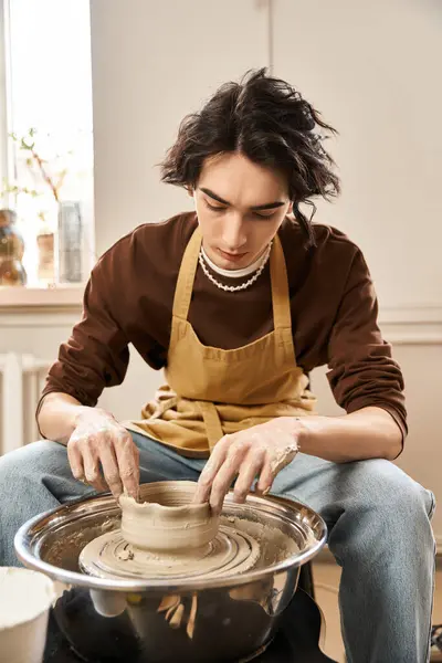 A fashionable man molds clay at a pottery wheel, immersed in artistic creation and expression. — Stock Photo