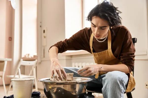 A handsome man is focused on crafting pottery in a bright and airy ceramics studio. — Stock Photo