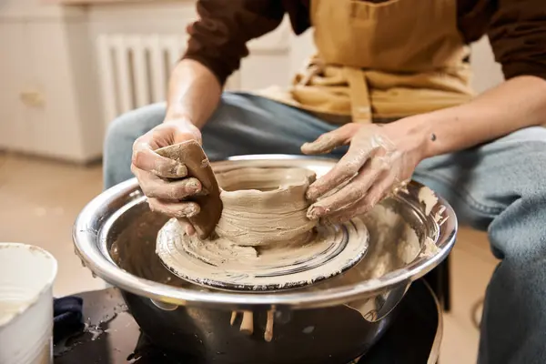A man skillfully shapes clay on a pottery wheel, showcasing his artistic talent in a cozy studio. — Stock Photo