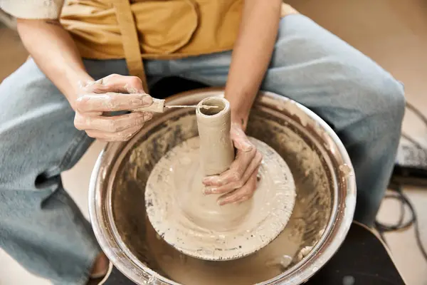 Hombre guapo hábilmente moldea una pieza de cerámica, mostrando creatividad en un estudio vibrante. - foto de stock