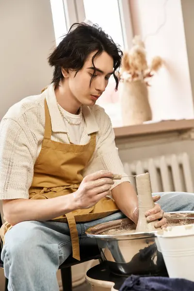 Un hombre expresa su lado artístico mientras moldea arcilla en un estudio de cerámica, inmerso en la creatividad. - foto de stock