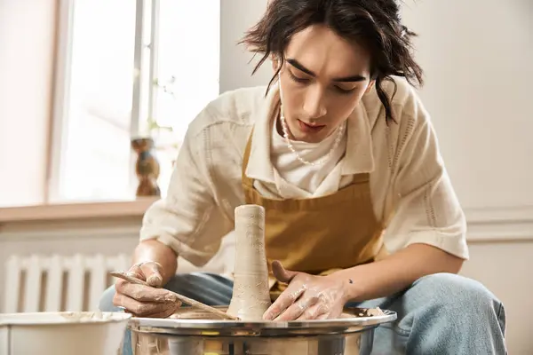 Handsome man carefully shapes clay into a beautiful pottery piece in an inspiring artistic space. — Stock Photo