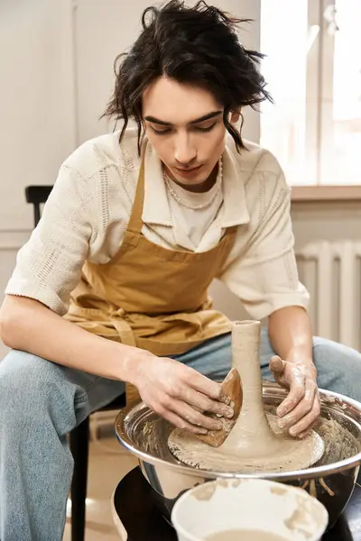 Stylish man focuses on shaping clay into art while surrounded by pottery tools and inspirations. — Stock Photo