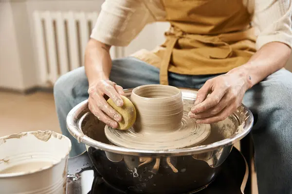 Un uomo creativo modella sapientemente ceramiche su una ruota in uno studio luminoso. — Foto stock